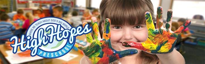 A child with paint on their hands and fingers.