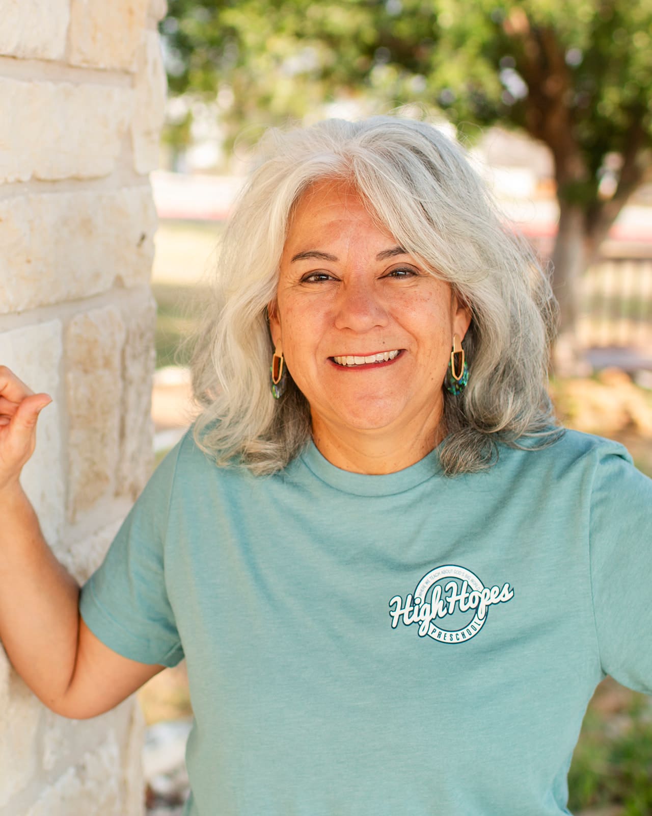 A woman with white hair is smiling for the camera.