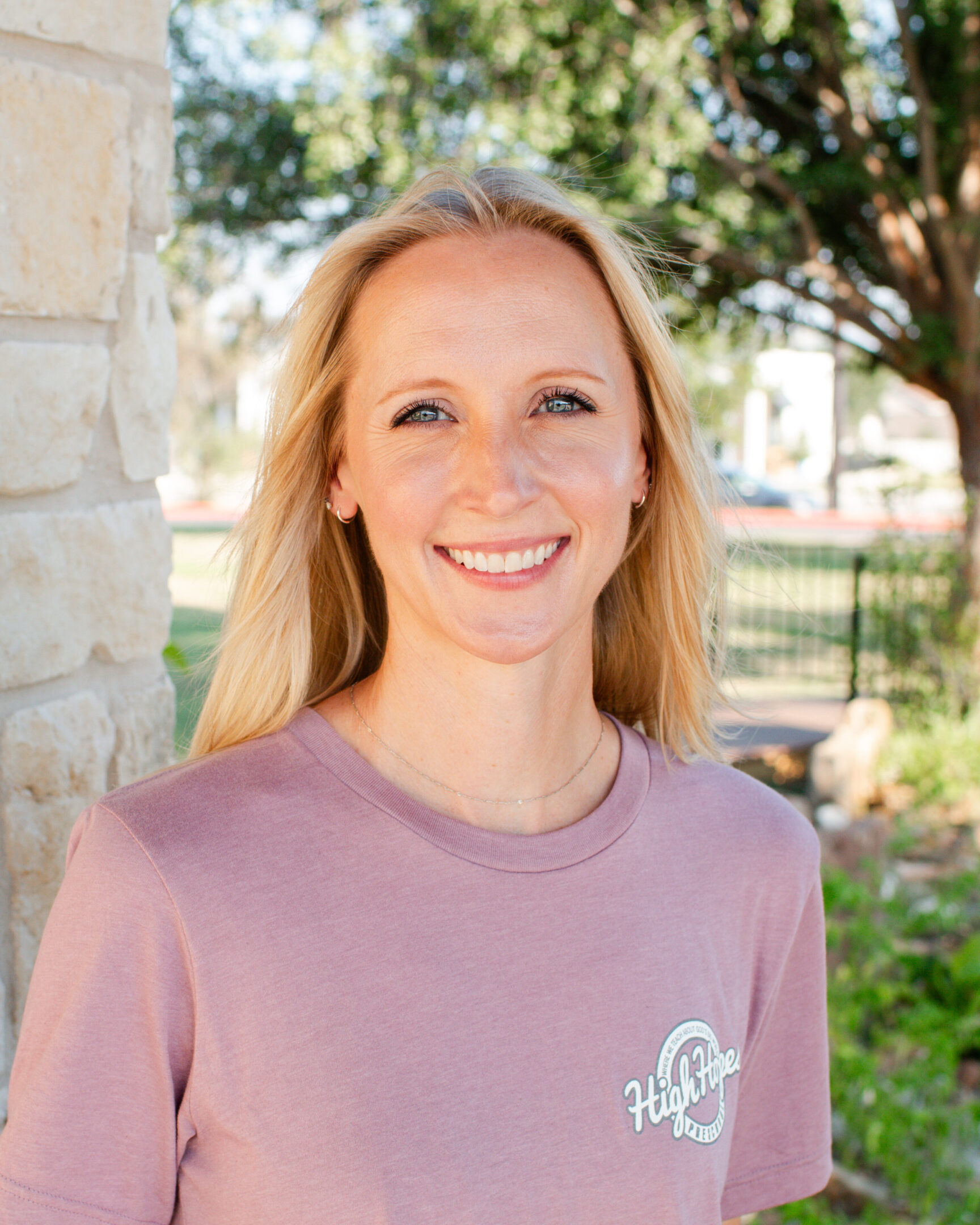 A woman in pink shirt smiling for the camera.