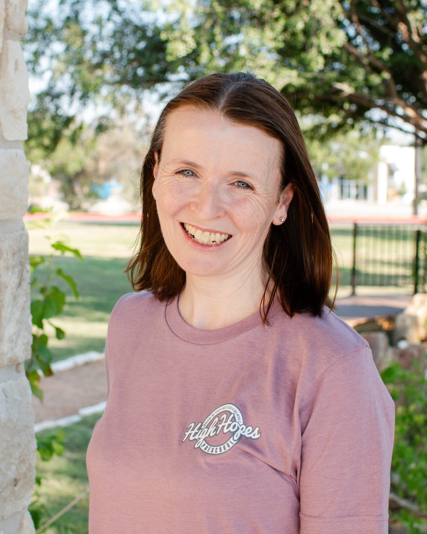 A woman in pink shirt smiling for the camera.