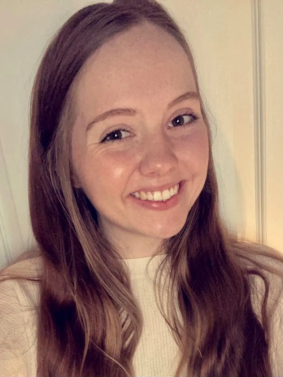 A woman smiling for the camera with long hair.